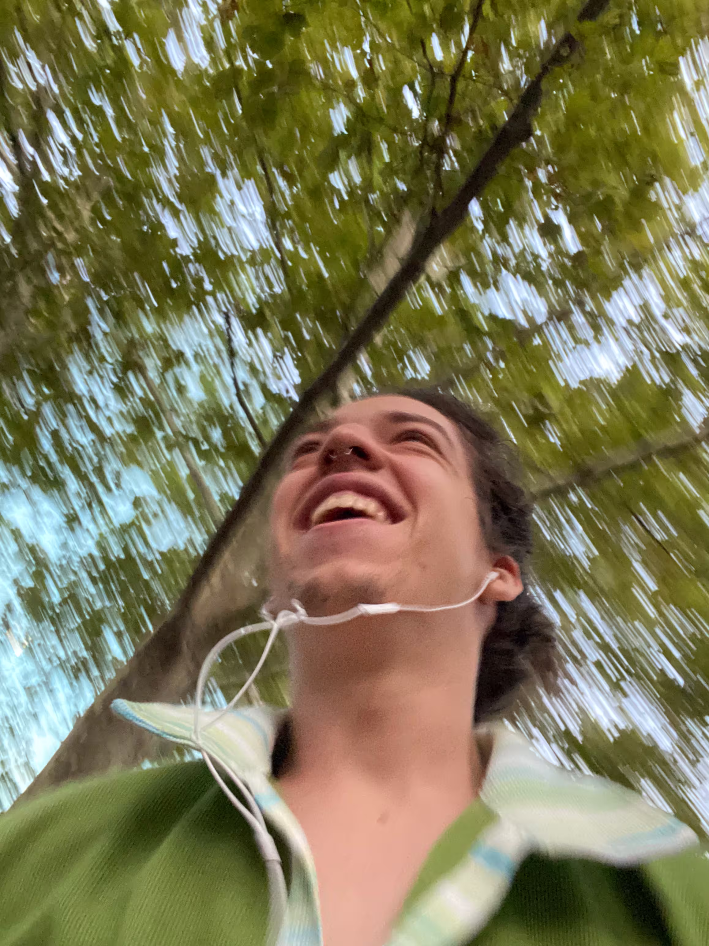 Me running for a train, green shirt, big smile, trees in background